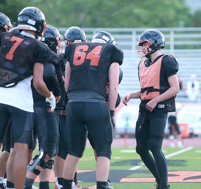 Douglas High quarterback Jackson Ovard calls a play in the huddle during the Tigers’ preseason scrimmage against Galena.