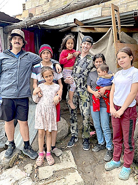 Western Nevada native Zach Harris and Maverick Baker with the Cortez family in March 2023 in a Columbian neighborhood. Harris said the structure behind them is the living quarters the family lived in before they built a permanent structure for them out of brick.