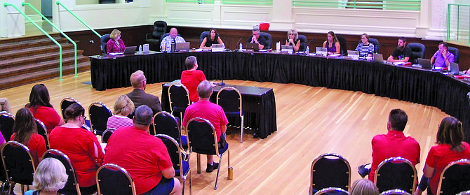 Teachers dressed to support “Red for Ed” ask the board for a more competitive pay scale compared to nearby districts.