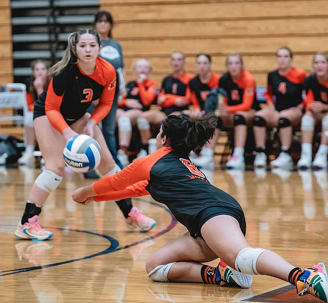 Douglas High’s Priya KC (8) dives to make a dig while Emersyn Worthington (3) follows the ball against Reno. The Tiger volleyball team has 16 contests under its belt so far this fall after a tough stretch to open the season.