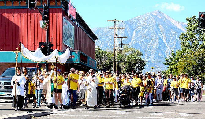 St. Gall Catholic Church parishioners pass by Sharkey’s on Sunday as part of a Eucharist Procession to Heritage Park in Gardnerville.