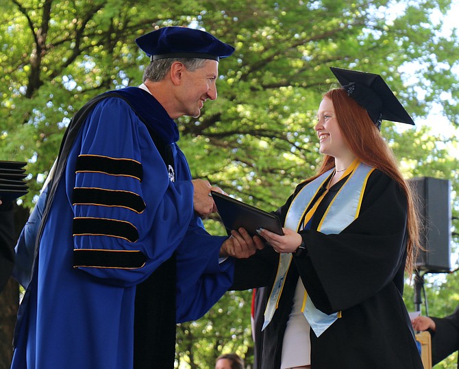 Western Nevada College President Kyle Dalpe provides a diploma to a graduate in May’s commencement ceremony this spring.