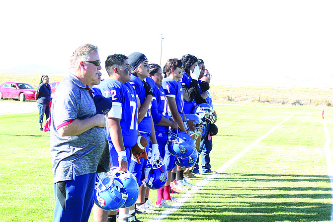 The McDermitt High School football team stands on the sideline for the National Antem prior to its game with Pyramid Lake on Saturday afternoon. It was the first game for the Bulldogs since the spring of 2021.