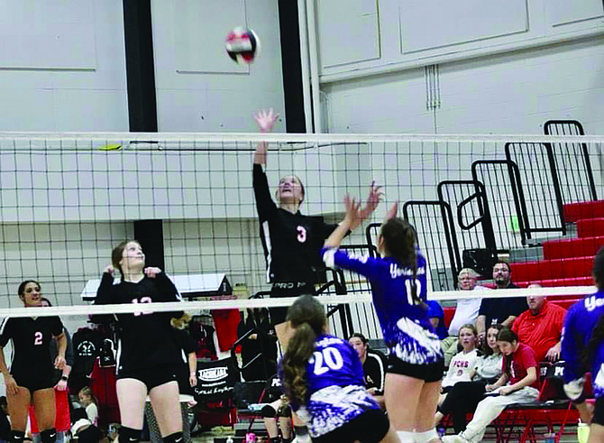 Raegan Burrows goes up for a solid tip against an attempted block from Yerington.