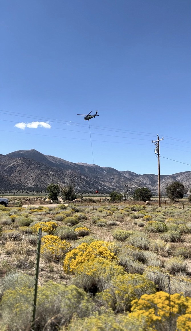A helicopter fills a bucket in a local pond near the Red Canyon Fire on Wednesday.