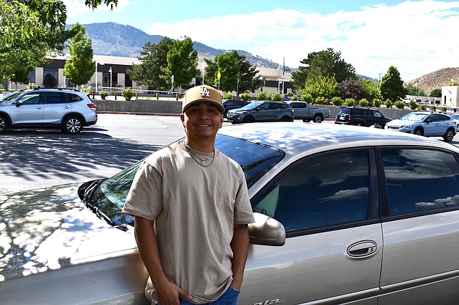 Western Nevada College student Jose Fausto Hernandez by his Chevrolet Impala.