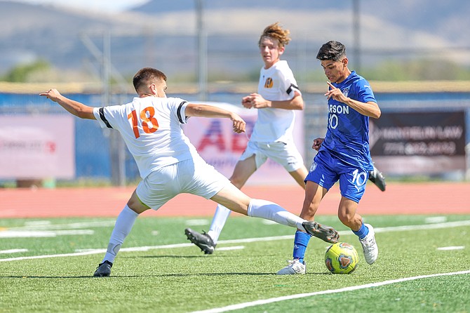 Douglas High's Alexander Vargas stabs at the ball on defense against Carson.