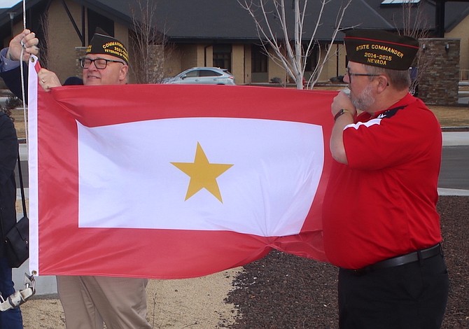 Former Veterans of Foreign Wars Commander Matthew ‘Fritz’ Milhelcic, left, and Sparks VFW member David Sousa, begin to raise a new Gold Star flag at the Gold Star Families Memorial in Sparks.