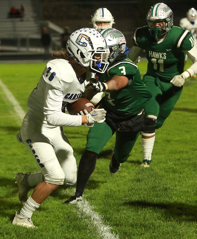 Carson High’s Isaiah Hurlbert (26) looks for room to maneuver after making a catch against Hug on Thursday night.