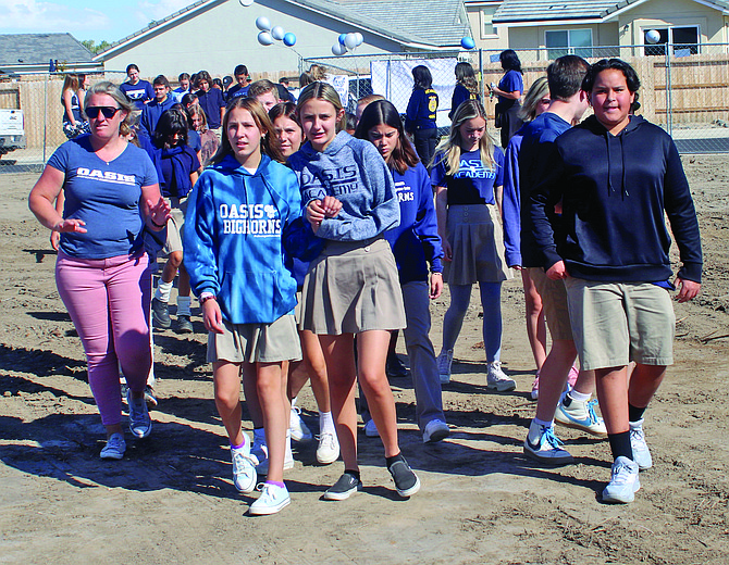 Students file into the construction site last week for the groundbreaking of a new building to house Oasis Academy College Prep.