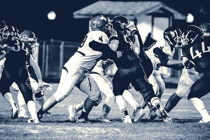 JOSH LANGE • provided to Great Basin Sun
Lowry's Roan Hornbarger fights through the Elko offensive line during Friday's game in Elko.