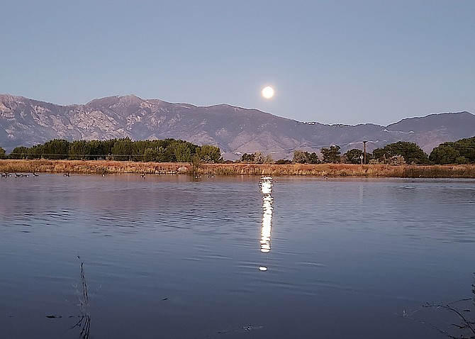 The last super moon of 2023 is reflected in the Dangberg Pond on Friday morning as it sets over the Carson Range in this photo taken by Thor Teigen.