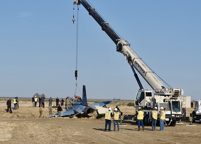 Different agencies prepare to remove a Navy F-16 last week after the jet left the runway during routine training at Naval Air Station Lemoore. The F-16 came from the Naval Aviation Warfighting Development Center at Naval Air Station Fallon.
