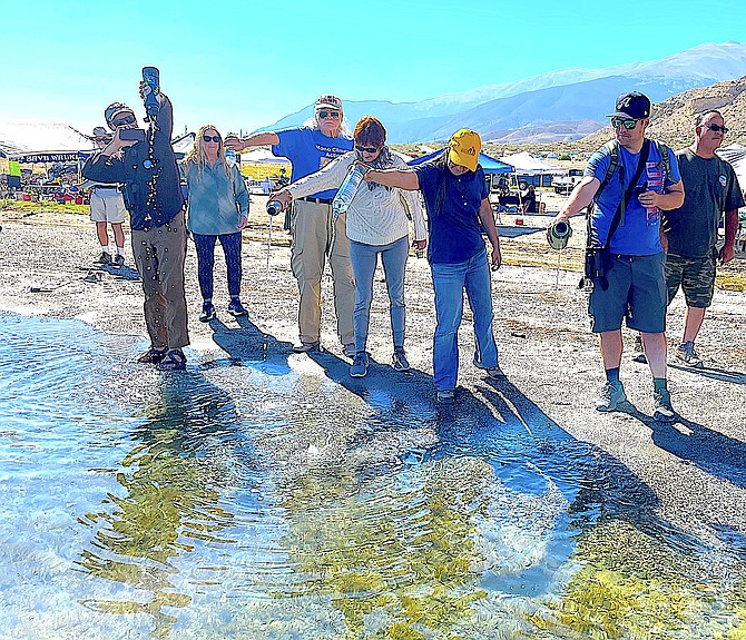 Visitors pour water into Walker Lake for a Rehydration Celebration of the lake's 15-foot rise. Photo by David Carle