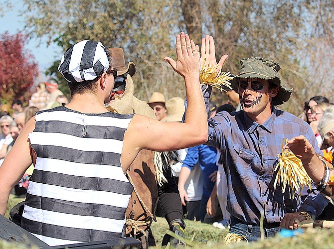 A member of the Stor-All Active Carson Valley 20-30 Club prisoners high fives a member of the Main Street Gardnerville team during last weekend's coffin races in Gardnervill.