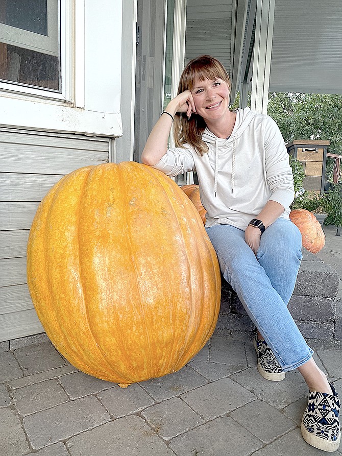 Avid Gardnerville gardener and beekeeper Jill Mayer with what can only be described as a great pumpkin she and her children grew. Photo special to The R-C by Matt Mayer