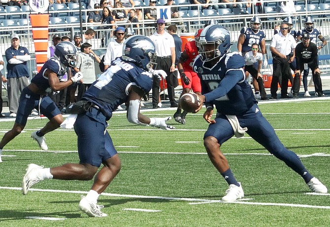 Nevada quarterback Brendon Lewis hands off to running back Sean Dollars during the Oct. 14, 2023 game against UNLV at Mackay Stadium.