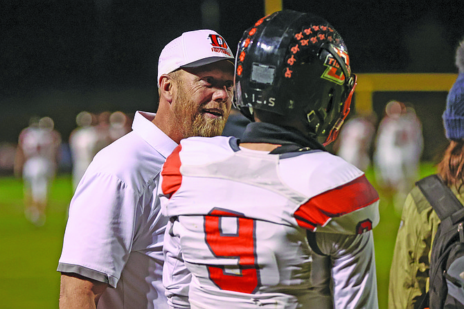 Current Douglas head coach Kyle Mays chats with quarterback Jackson Ovard (9) on the sideline.