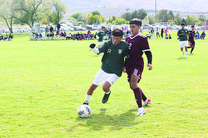 Lowry's Jovanny Cuevas fends off a West Wendover defender in the Buckaroos' 1-1 tie against the Wolverines on Saturday in Winnemucca.