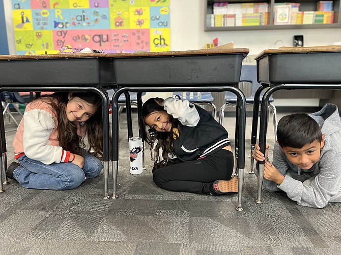 Third graders from Mark Twain Elementary School drop, cover and hold on during Thursday’s Great Nevada ShakeOut drill.