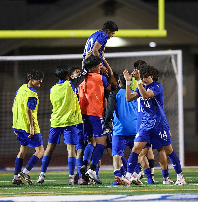 The Carson High boys soccer team lifts Steve Gomez (10) after Gomez scored in stoppage time to beat Damonte Ranch, 1-0, on Wednesday.