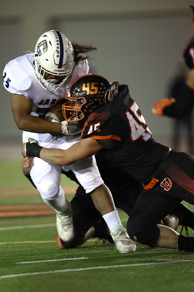 Douglas’ Aaron Tekansik stops Carson runner Angelo Macias during the Tigers’ shutout win Friday night.