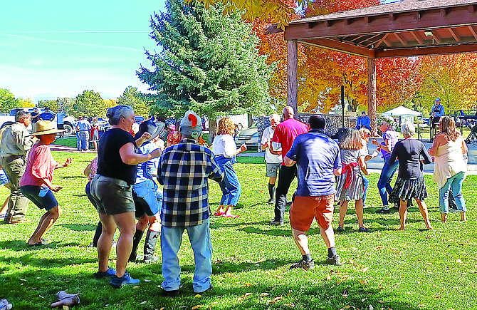 Visitors to the Sertoma Oktoberfest do ‘The Chicken Dance,’ in Heritage Park on Sunday to the music of the Bratwurst Band. Photo special to The R-C by Kathy Schuman
