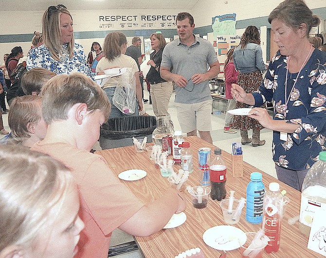 Dentist Dr. Celeste M. Eckerman, a Minden Elementary parent volunteer, demonstrates what certain drinks can do you to your teeth with an experiment involving popular drinks and baking soda during the Minden Elementary School Health Fair on Oct. 12.