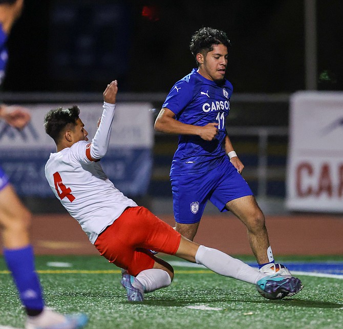 Carson High’s Joel Alcaraz is met with a tackle from Wooster’s Silvestre Mellin De Jesus in the box, during the Senators’ 1-0 win over the Colts Monday night.