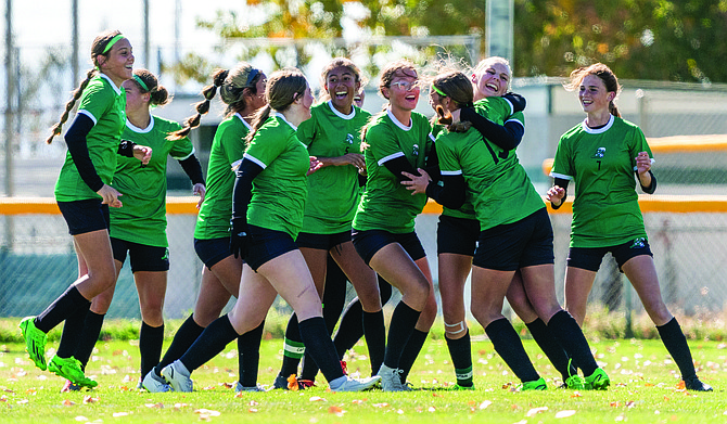 The Lady Wave soccer team celebrates Kourtnie Simper (right) scoring the team’s third goal with less than a minute left in the first half of Saturday’s playoff win over North Tahoe in Fallon.