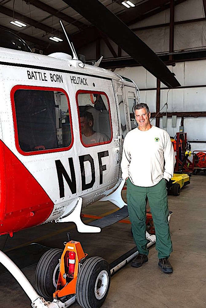 Nevada Division of Forestry Chief Pilot Kris Kirkland stands next to a UH-1H Huey on Oct. 16. The helicopter is one of three available to the Tahoe Basin on high fire risk days. 
Katelyn Welsh | Tahoe Daily Tribune