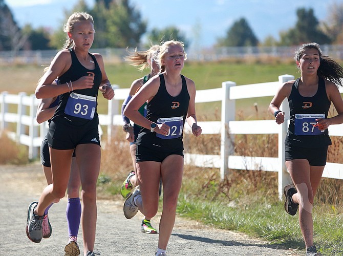 Douglas High’s Lucy Nord, left, Ayla Nelson, middle, and Niza Barton start to climb the hill at the back of the Class 5A North regional cross country course at Rancho San Rafael Park in Reno.