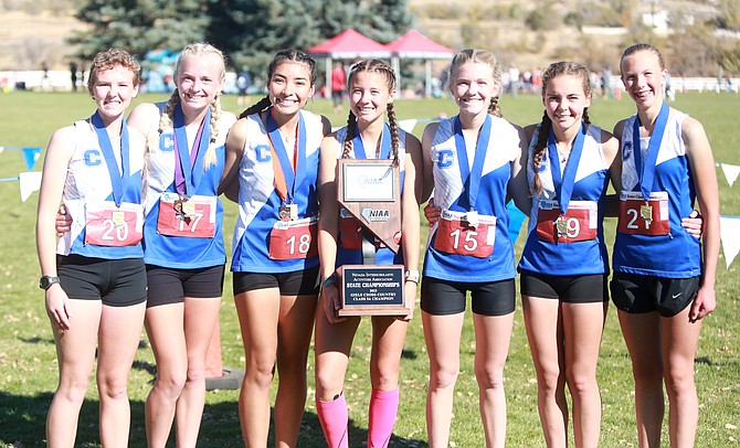 The Carson High School girls cross country team poses with the Class 5A state championship trophy after winning their second straight state title. Pictured from left to right are Eleanor Romeo, Vea Miner, Brianna Rodriguez-Nunez, Hannah Budd, Madison Hager, Jinnie Ponczoch and Anna Shane.