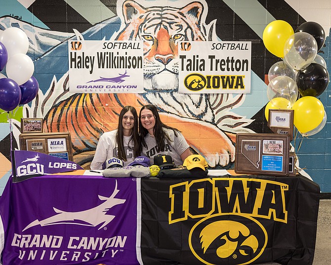 Douglas High senior Haley Wilkinson (accompanied by Talia Tretton, right) signs her National Letter of Intent to play softball at Grand Canyon University next season. Wilkinson has been a Class 5A North first-team selection each of the past two seasons.
