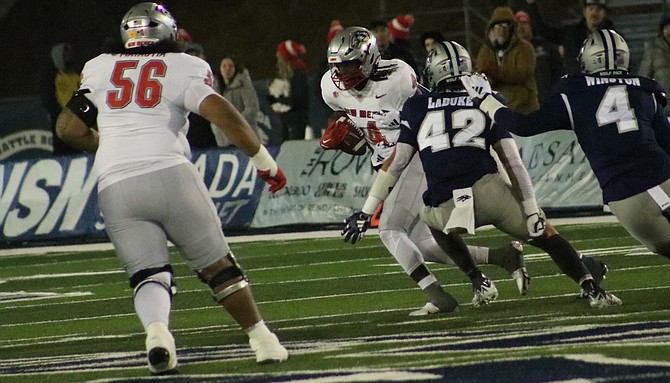 Jackson LaDuke (42) and Eli’jah Winston (4) close in on New Mexico’s Caleb Medford  earlier this season.