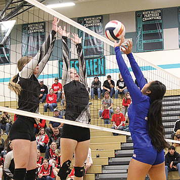 McDermitt's Vina Tom attempts to tip the ball over a pair of Round Mountain blockers  during Thursday quarterfinal match of the NIAA 1A State Championships at North Valleys High School in Reno.