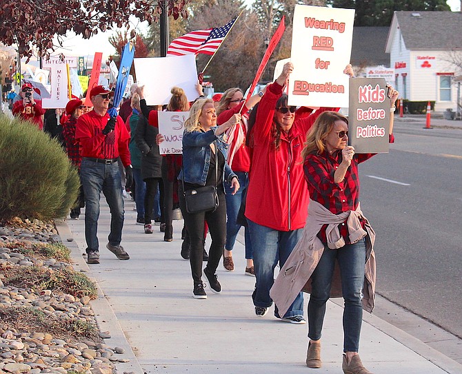 We Deserve a Better Board supporters march down Main Street in Gardnerville on Monday.