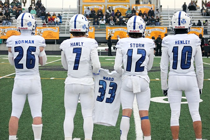 Eatonville captains Dylan Norman, Payton Hanly, Riley Storm, and Max Henley brought a special jersey with them to the coin toss before their first-round game in the state playoffs.