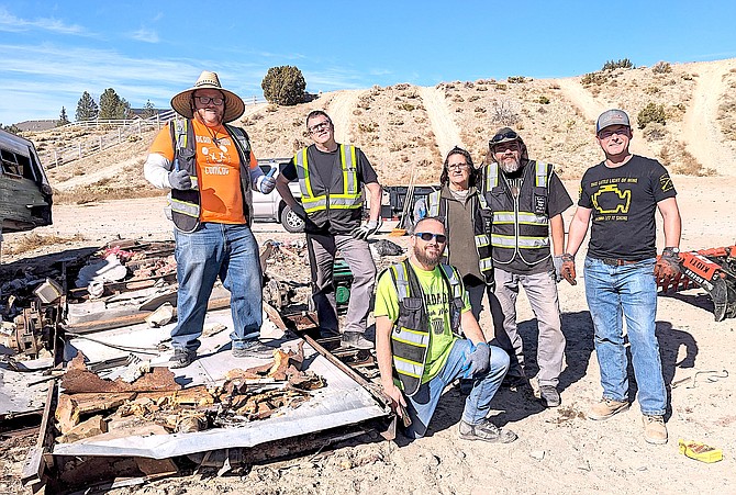 The Desert Pigs take a break from their labors above Johnson Lane on Monday. At right is Chris Pattison with Carson Demolition who donated his company's equipment and time for this project. Photo Special to The R-C by Asa Gilmore