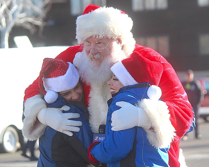 Santa gets a hug from Channel 2 news personalities during the 2021 Drive-By Food Drive at the Carson Valley Inn.