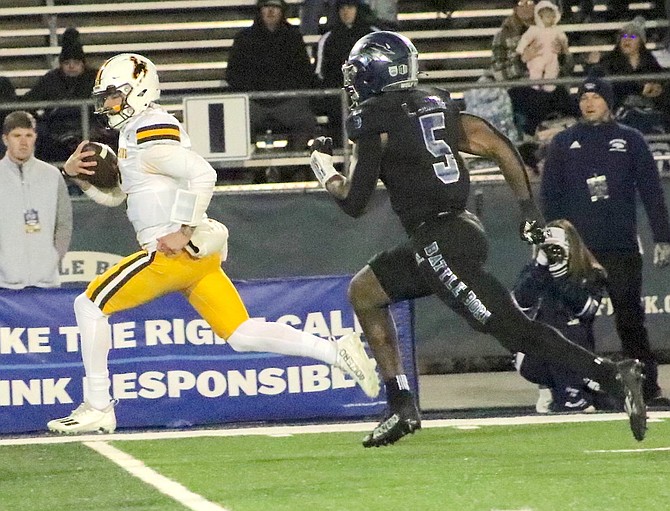 Nevada defensive back Emany Johnson trails Wyoming quarterback Andrew Peasley, who ended up in the end zone on this first-quarter run Saturday night.