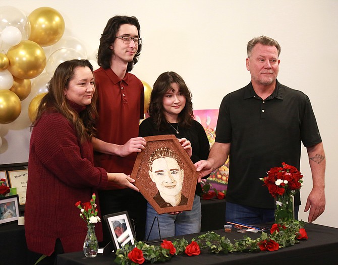 The Roman family holds a floragraph memorial portrait featuring the face of Jake Roman, who will be honored at the Rose Parade on Jan. 1 by Donor Network West. Pictured from left to right are Susan Roman, Mike Roman, Lily Roman and Blair Roman.
