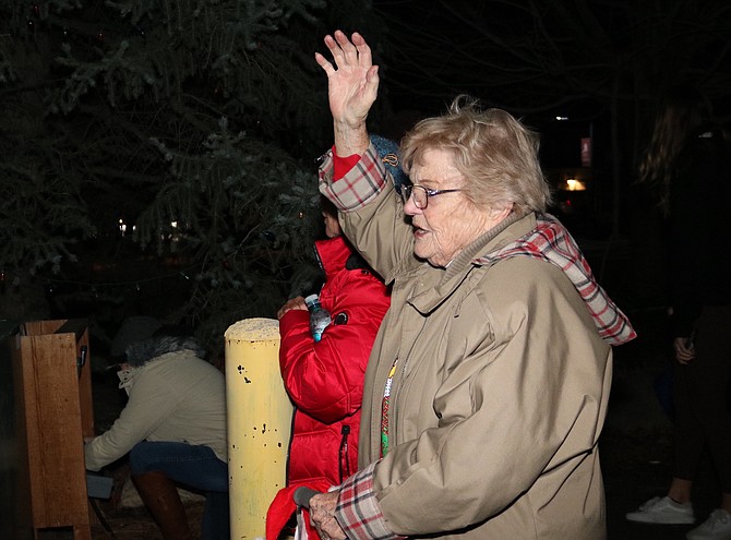 Marian Vassar calls the crowd to order in preparation for the lighting of Hopie Falcke's Christmas tree on Friday night.