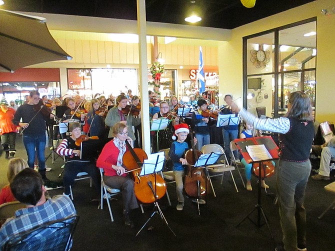 String instrument players of all ages at a previous Christmas Carol play along.