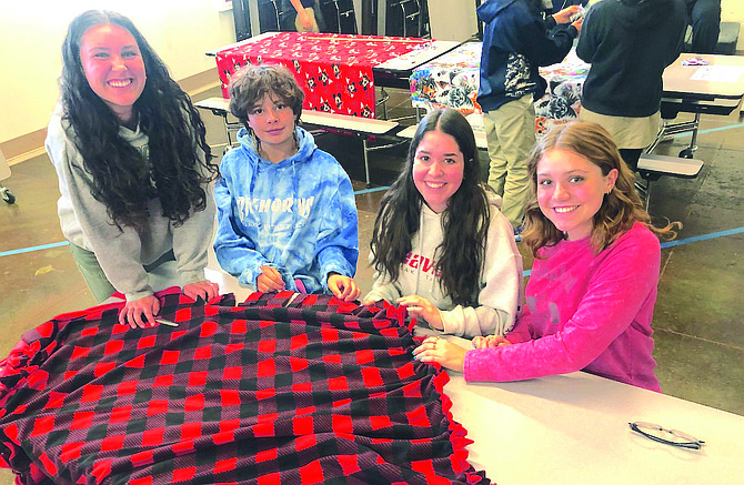 From left to right Alyssa Ayers, Lila Montero, Anna Springfield and Halle Feest tie a blanket.