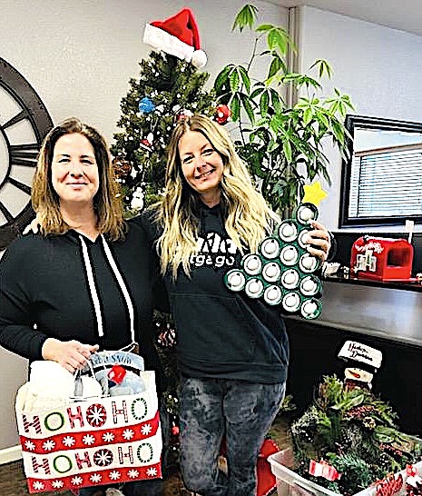 Executive Director of Family Support Council Veronica La Chance accepts gifts for the Council's shelter from Guild Mortgage's Rosalind Zellmer.