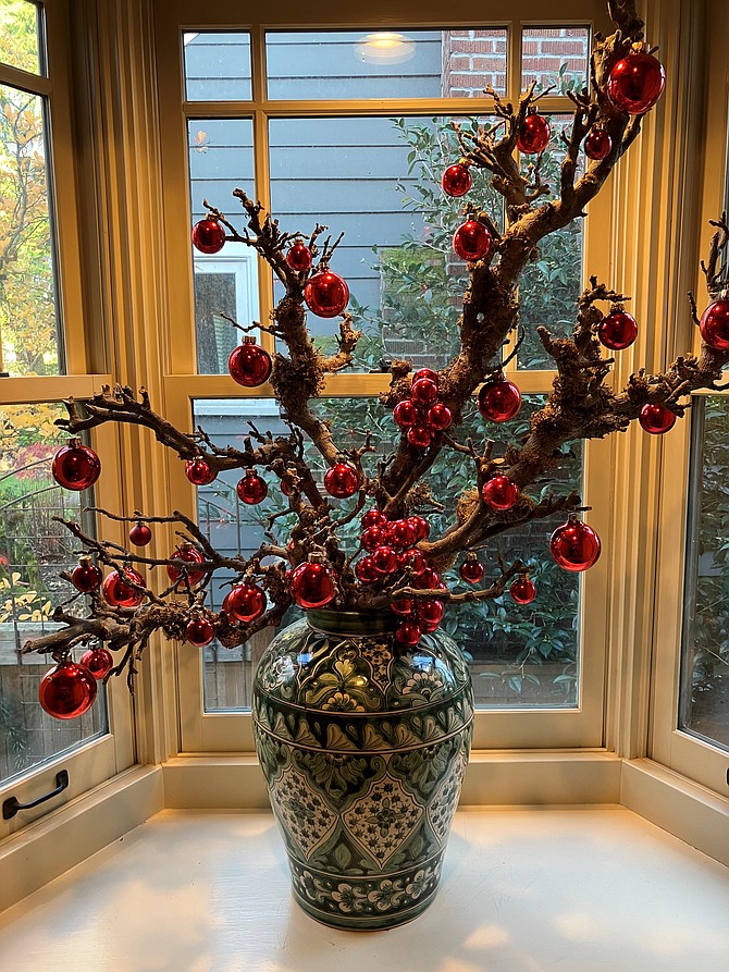 The branches with the red ornaments in the green Talavera pot are prunings from an old apple tree.