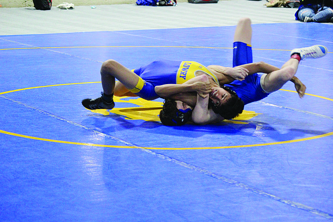 Lowry’s Kruz Gomez takes on South Tahoe’s Charlie Bergquist during a dual on Thursday night. Gomez won the 113-pound weight class at the Cody Louk Invitational.