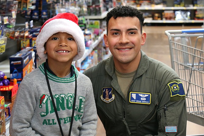 Air National Guard Staff Sgt. Brian Vargas, right, takes Trueth Fernandez, second-grader, of Seeliger Elementary School shopping for Holiday with a Hero Wednesday.