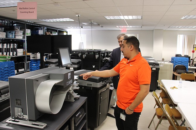 Carson City Chief Deputy Clerk Miguel Camacho and Carson City Clerk-Recorder Scott Hoen describing an ES&S DS450 ballot scanner and tabulator — slated to be replaced by an ES&S DS950 — in the elections room in the courthouse on Nov. 28.
